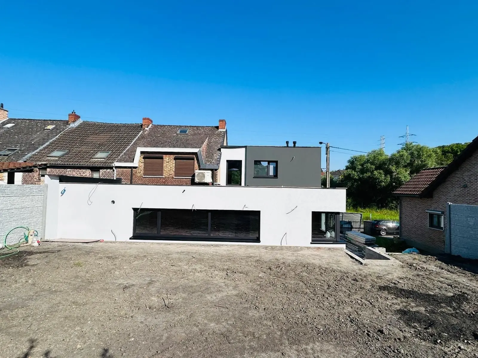 L’annexe terminée, façade blanche et grandes fenêtres, à Charleroi