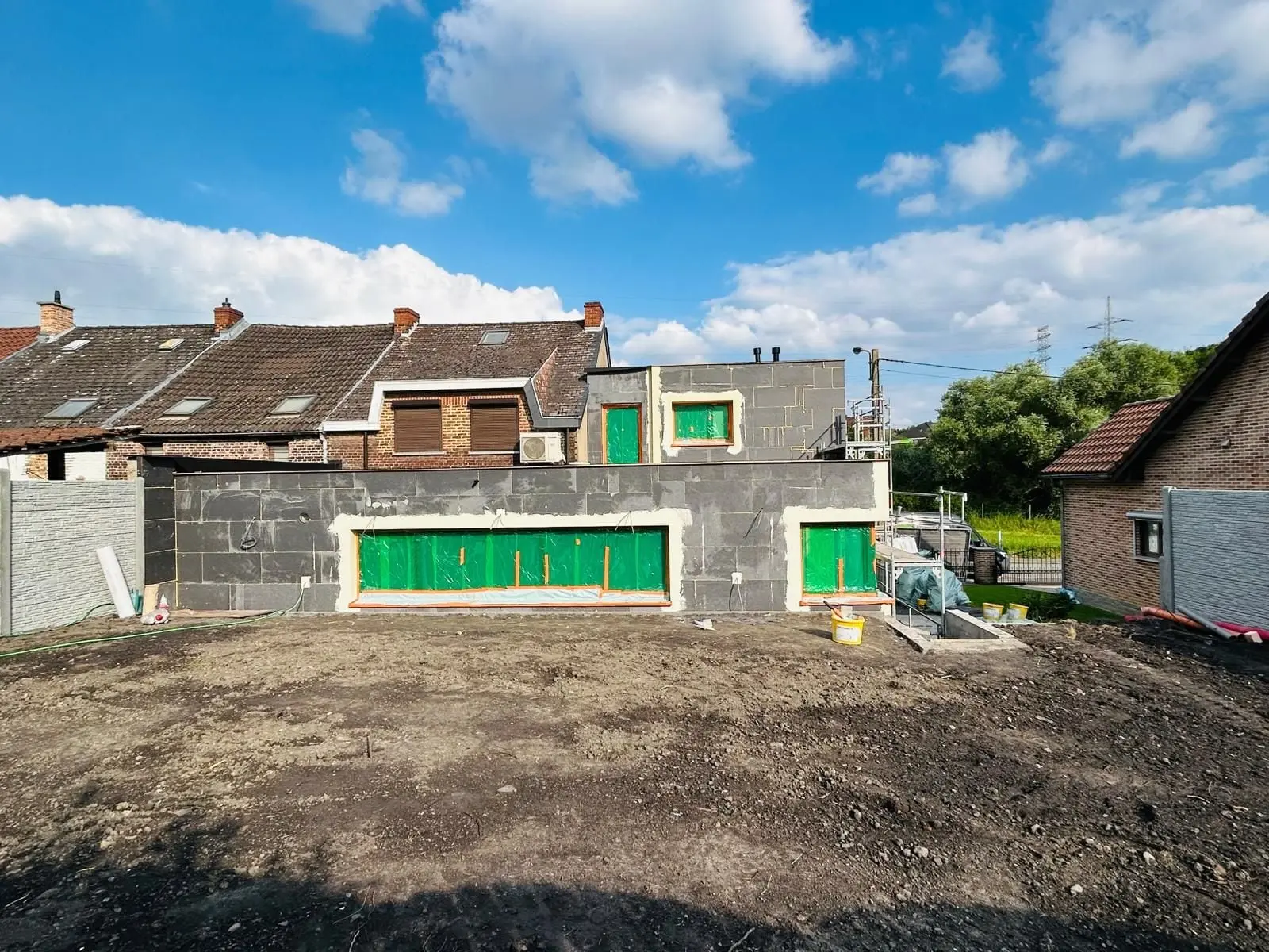 L’annexe côté jardin, panneaux noirs posés, fenêtres protégées, à Charleroi