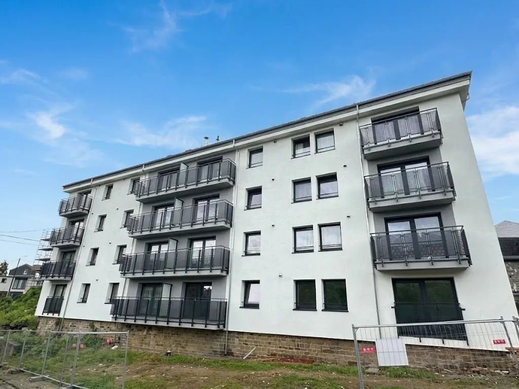 L’immeuble à balcons terminé, façade blanche, à Namur