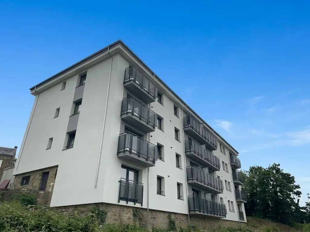 Le même angle terminé, façade blanche sous un ciel bleu, à Namur