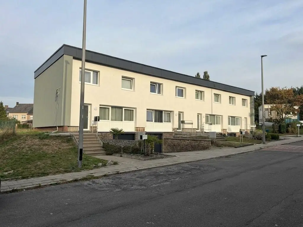 La rangée de maisons terminée, façade crème, à Charleroi