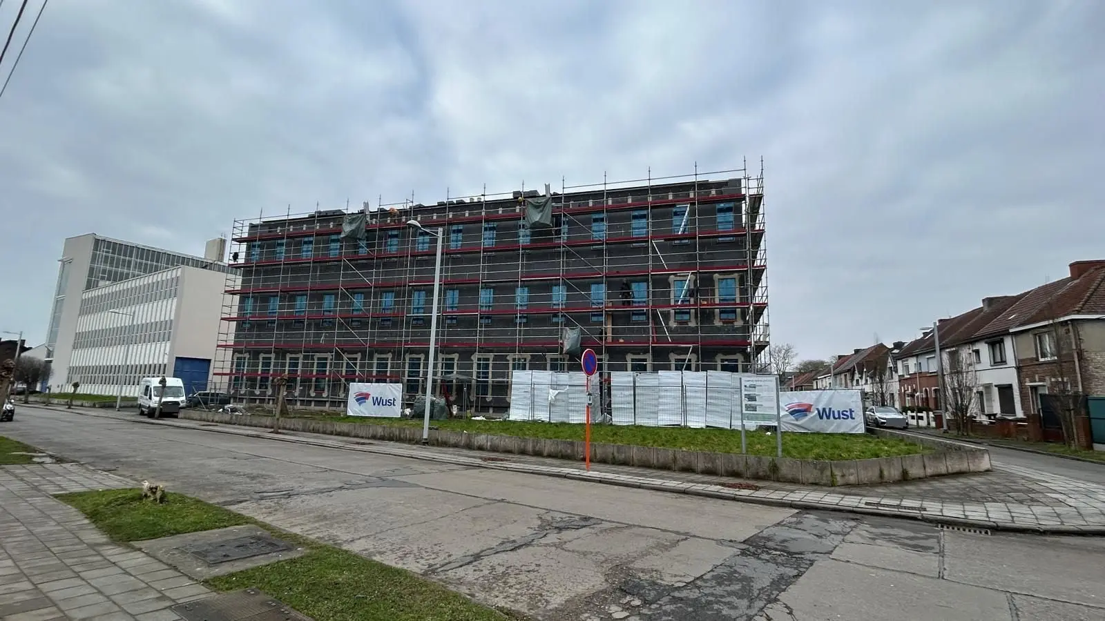 Le même immeuble sous échafaudage, vu du carrefour, à Mons