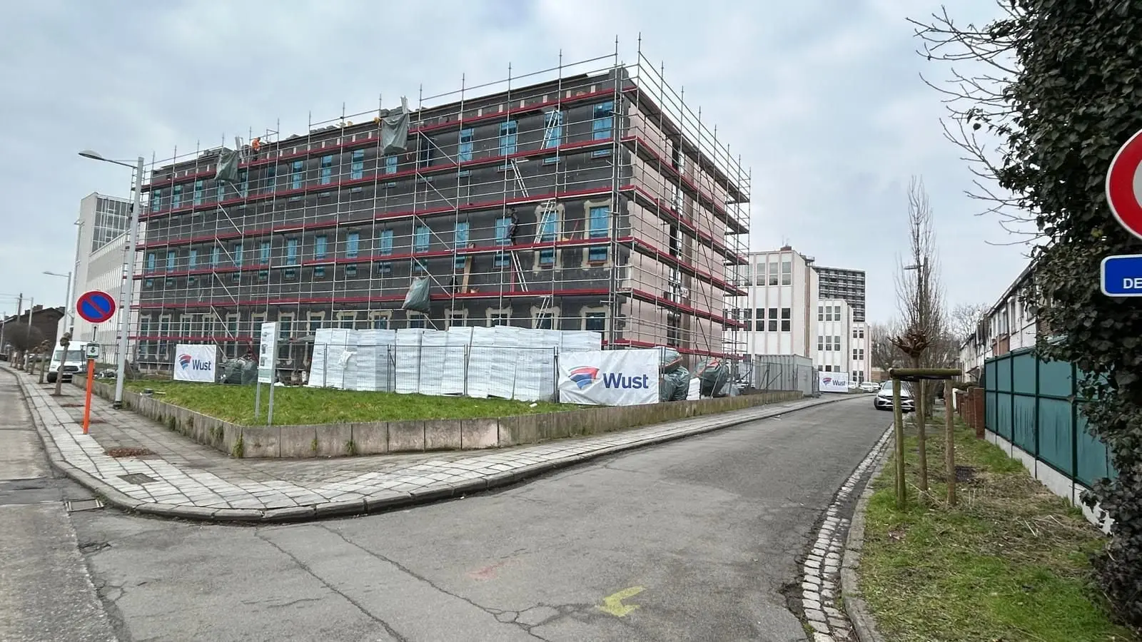 Le même immeuble sous échafaudage, vu de l’autre côté de la rue, à Mons