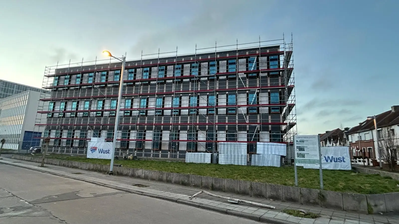 Le même immeuble sous échafaudage, en fin de journée, à Mons