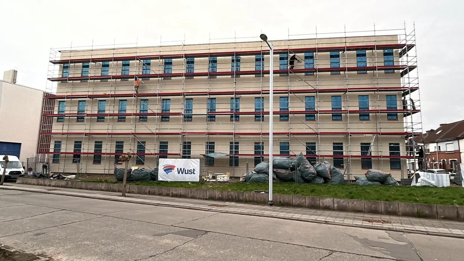L’immeuble avec sa sous-couche crème, fenêtres encore protégées, à Mons