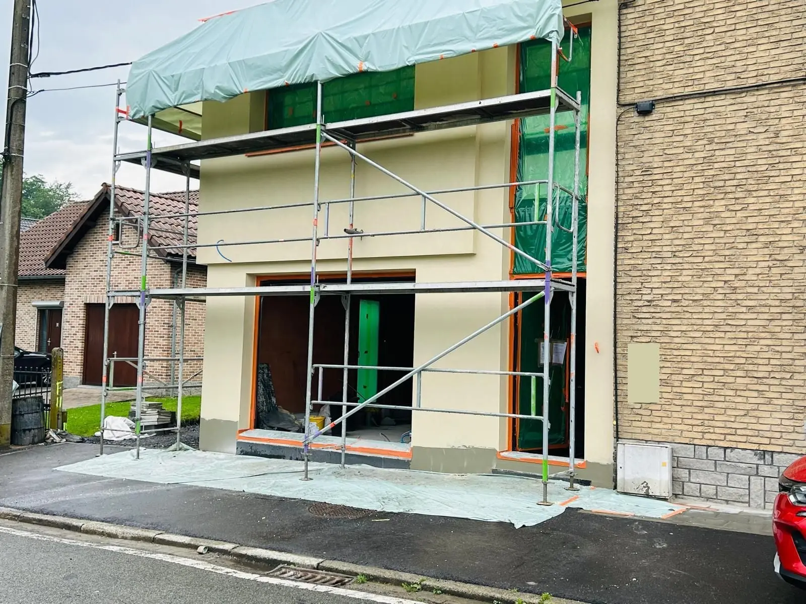 La façade avant sous échafaudage, couche crème, à Charleroi