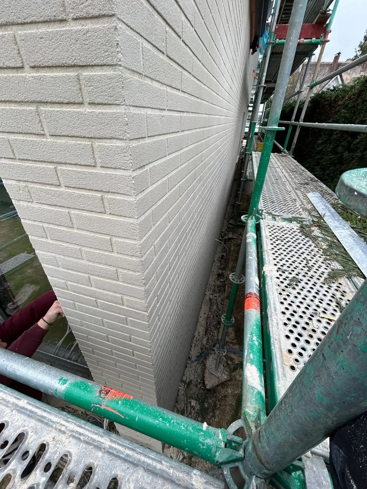 L’arête d’un mur à l’aspect brique, depuis l’échafaudage, à Auderghem
