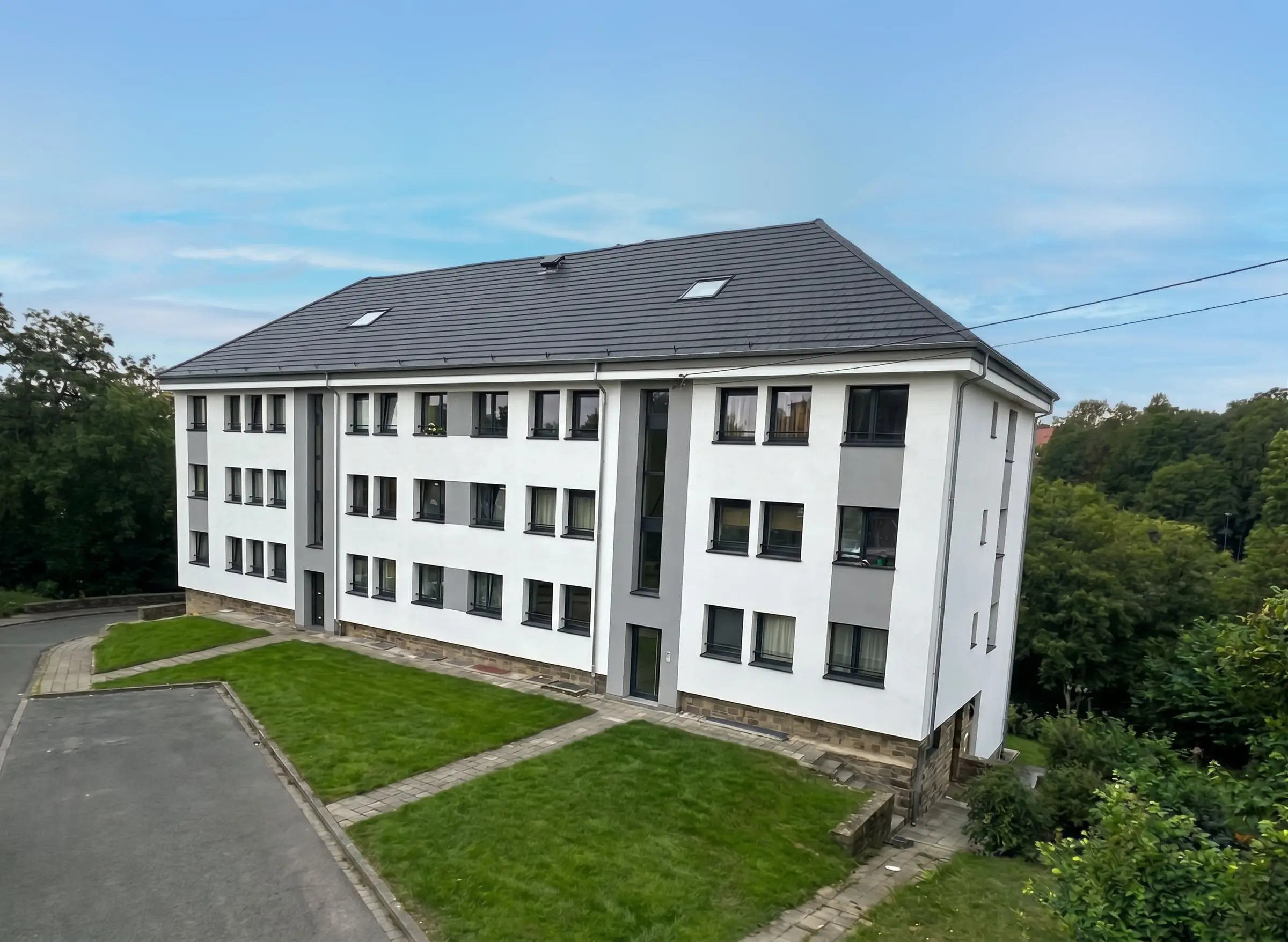Immeuble de trois étages à Namur, façade blanche et grise terminée, vu d’en haut