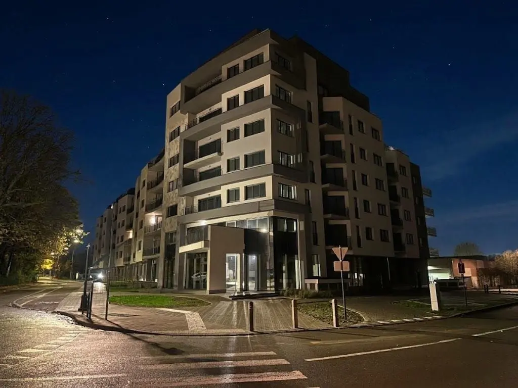Immeuble d’appartements au coin d’une rue, de nuit, à Evere
