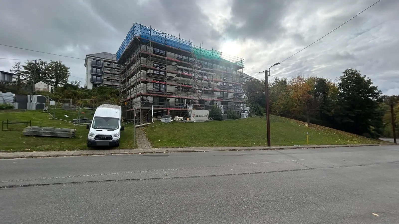 L’immeuble à balcons sous échafaudage, vu de loin, à Namur