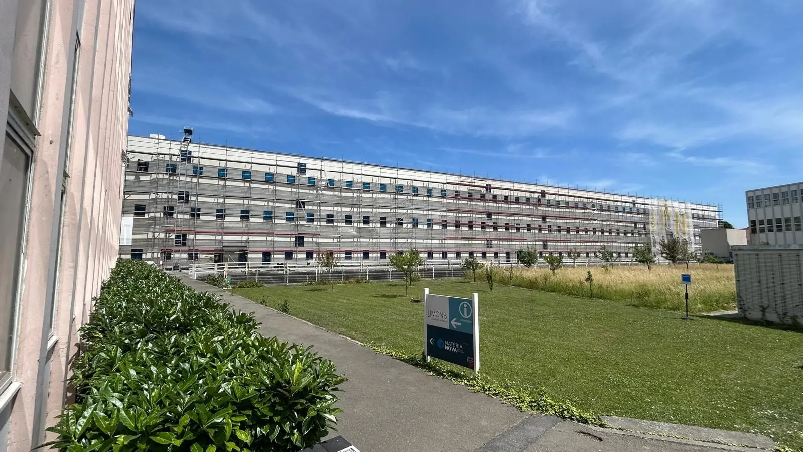Longue façade de l’Université de Mons sous échafaudage