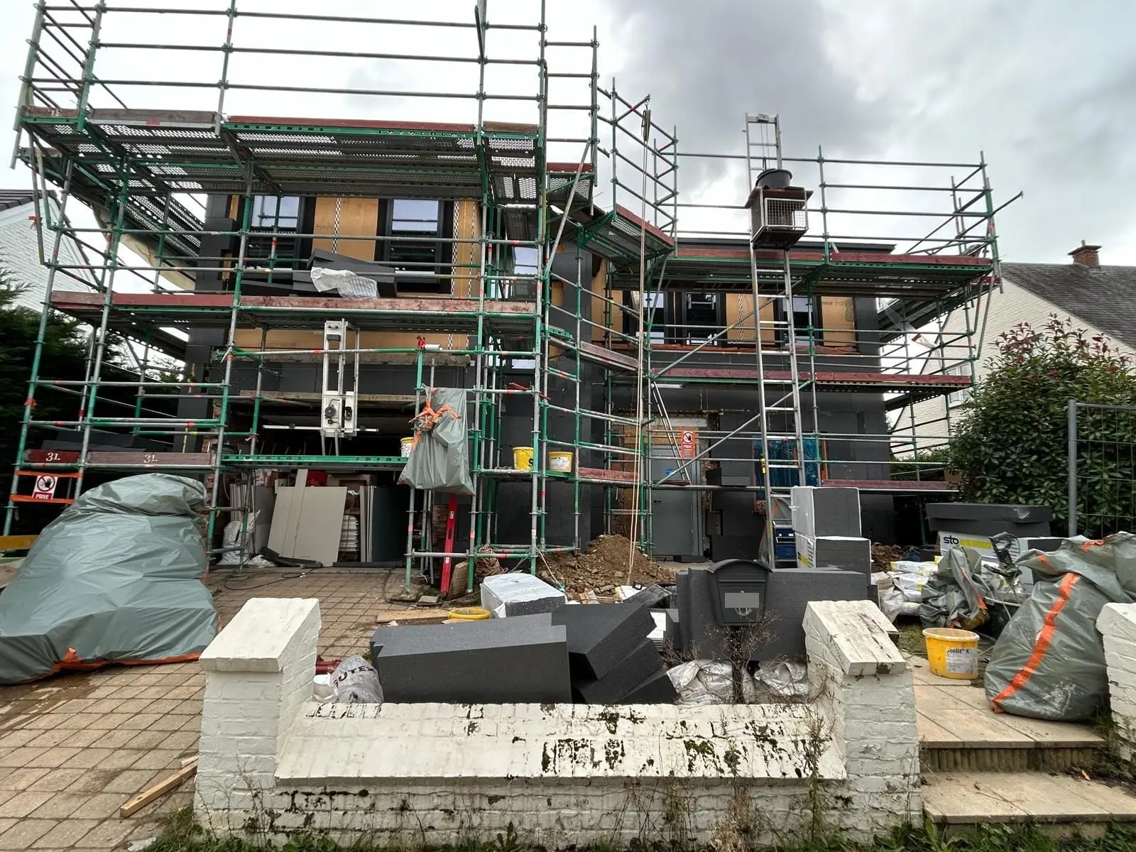La maison sous échafaudage côté rue, panneaux posés, à Auderghem