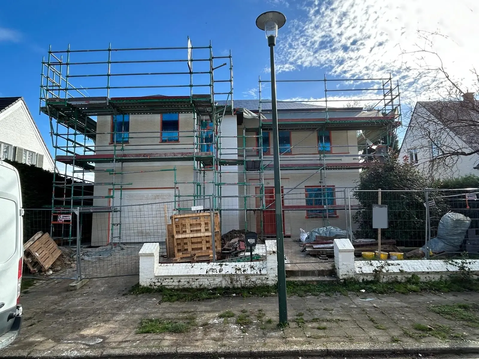La façade côté rue sous échafaudage, couche claire posée, à Auderghem